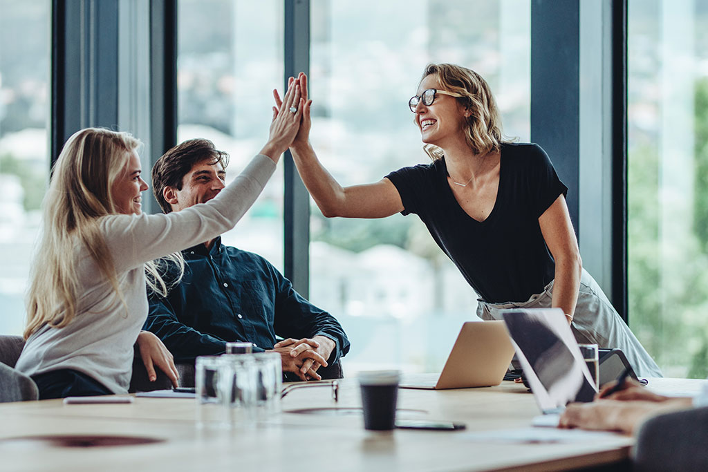Young professionals high-fiving each other