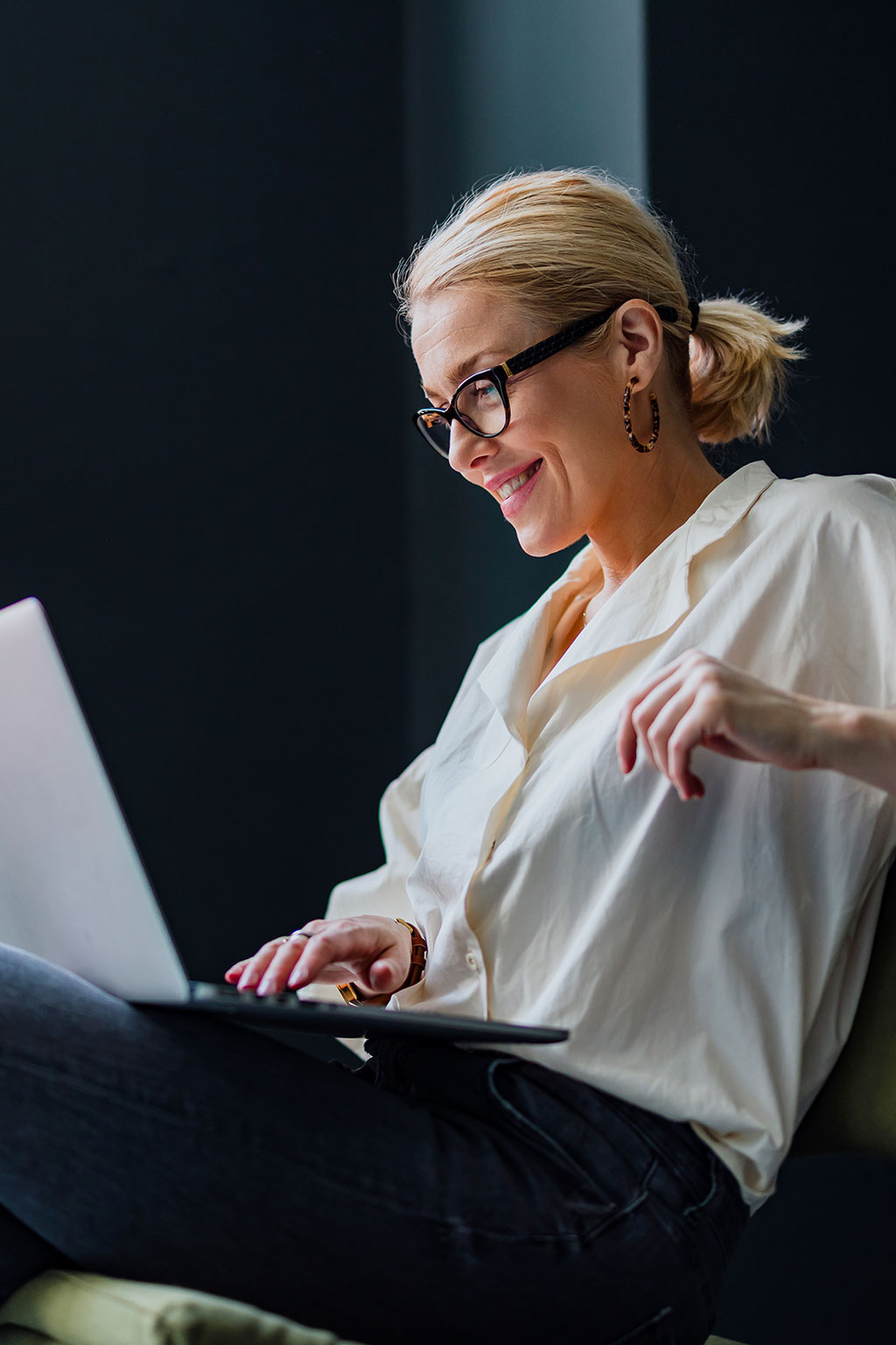 Business woman sitting down happy looking at computer