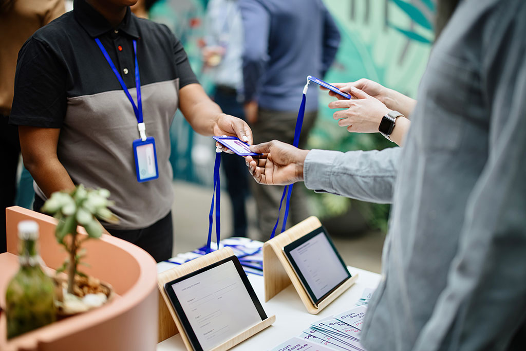 Person giving out name tags at conference