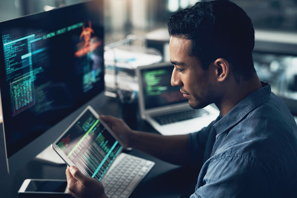 Younger man coding at work