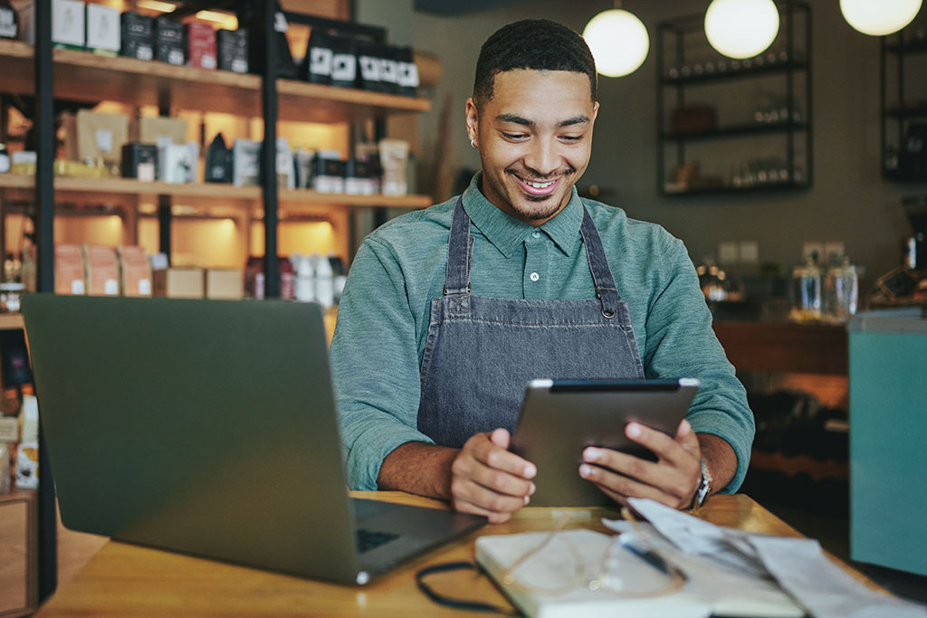 Business owners going through papers in shop with laptop on table