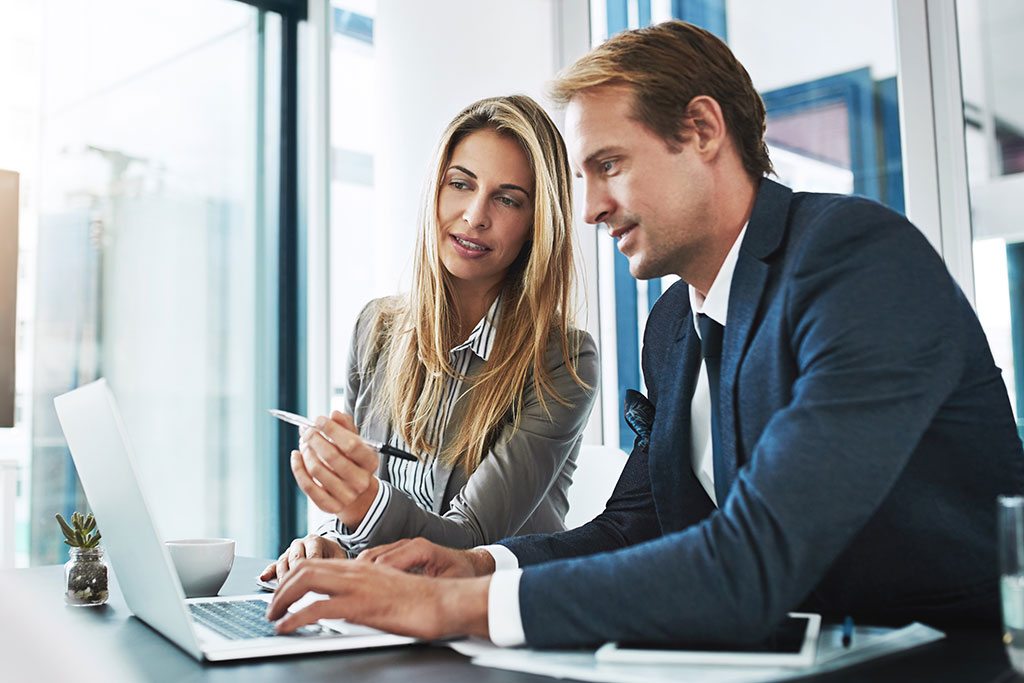 Co-workers having discussion looking at laptop