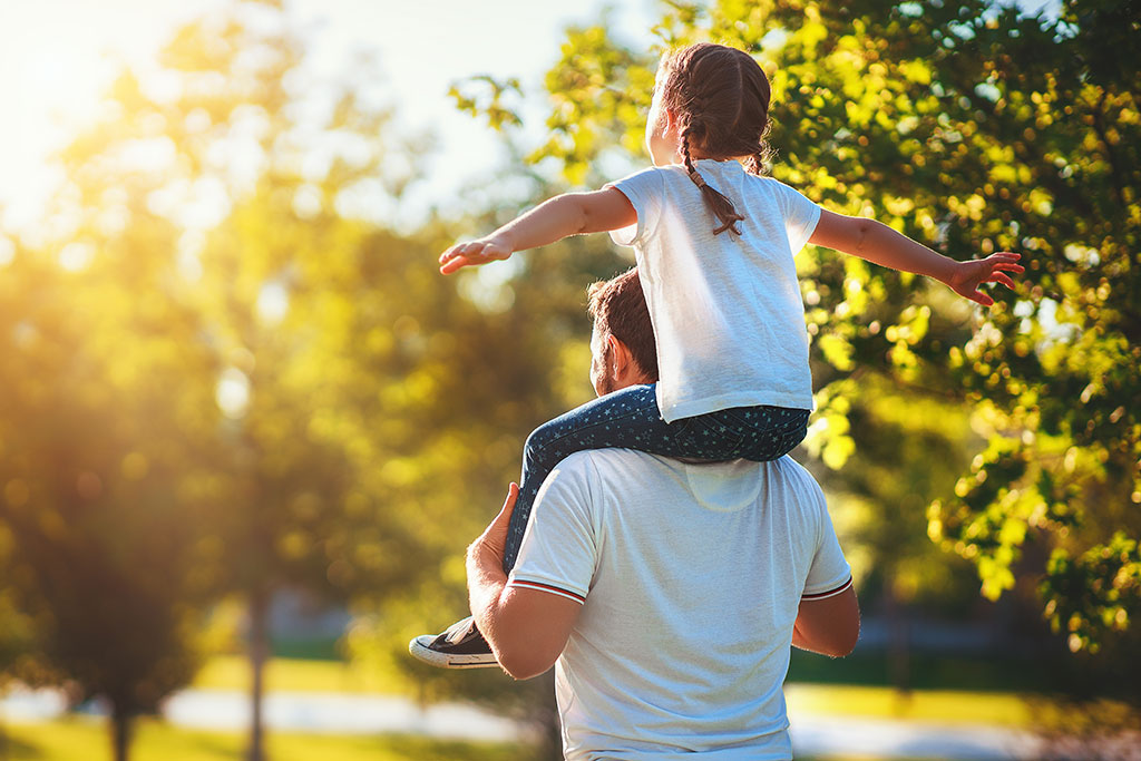 Daughter on dad's shoulder outside