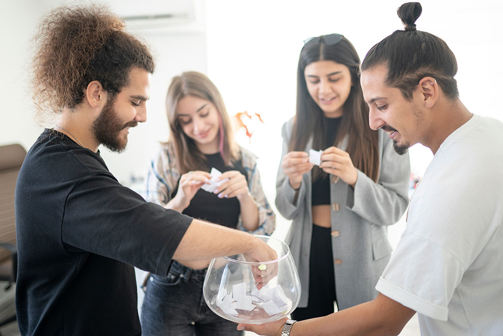 Friends picking paper from bowl