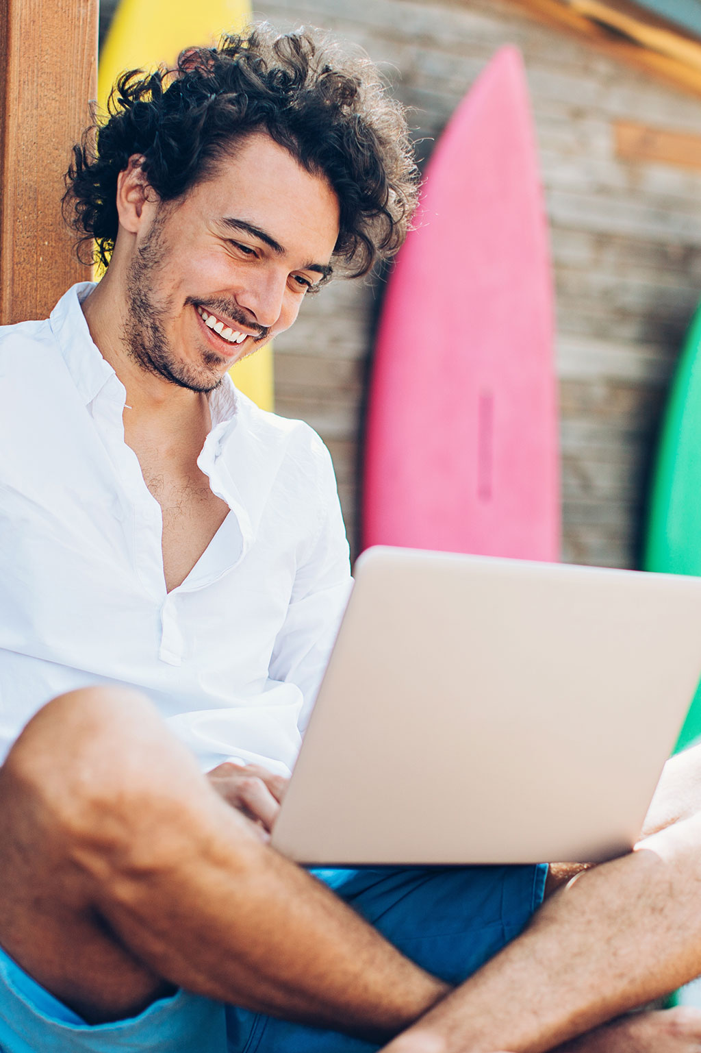 Man working on laptop at beach