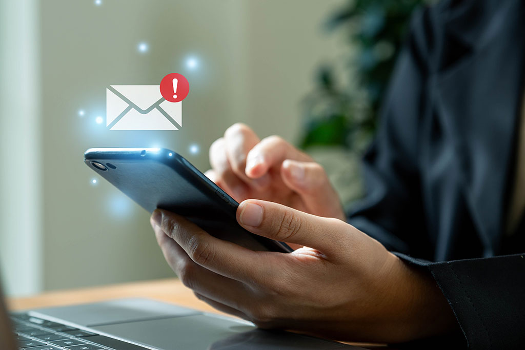 Email graphic above person holding phone